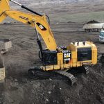 Caterpillar 6015B Excavator Loading Trucks with coal at coal mine with 2 trucks