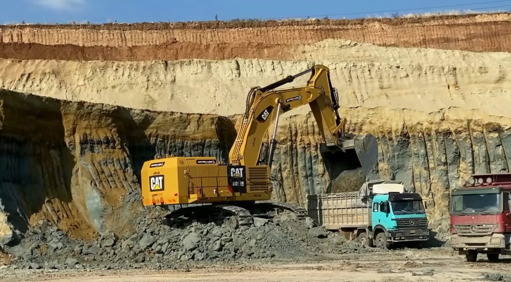 Excavator loading trucks