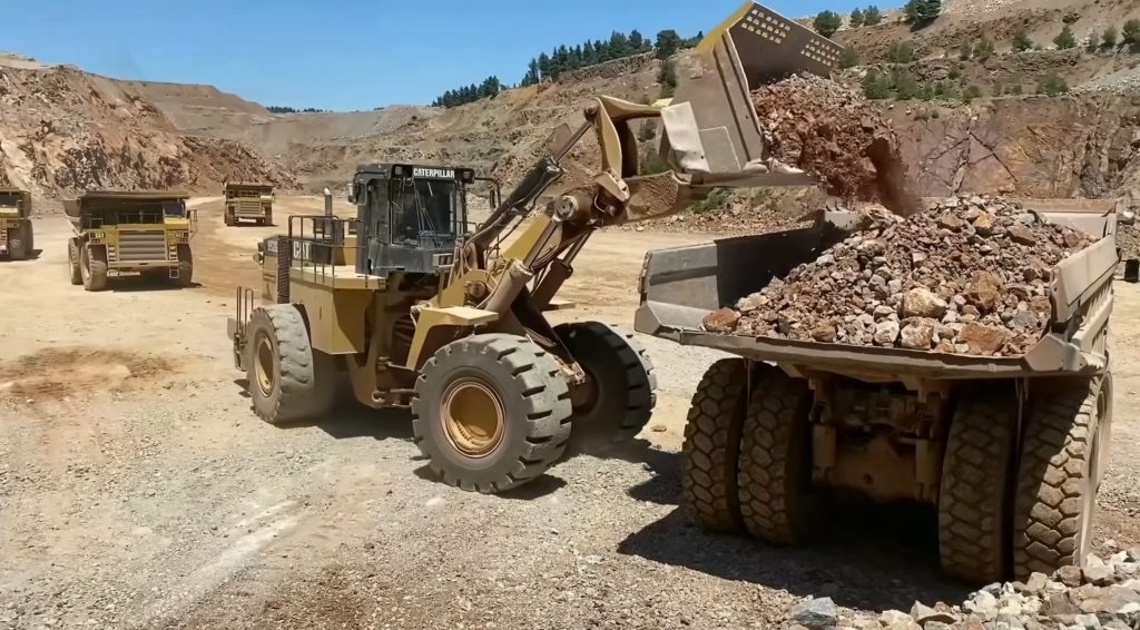 Wheel loader loading hard rocky material on dumper