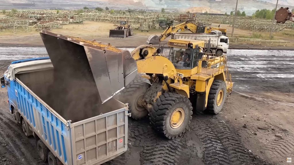 Wheel loader loading coal on truck at mining site