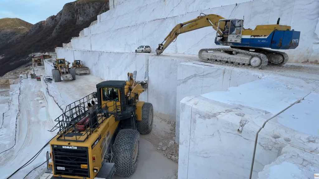 Komatsu wheel loader helping excavator extracting marble