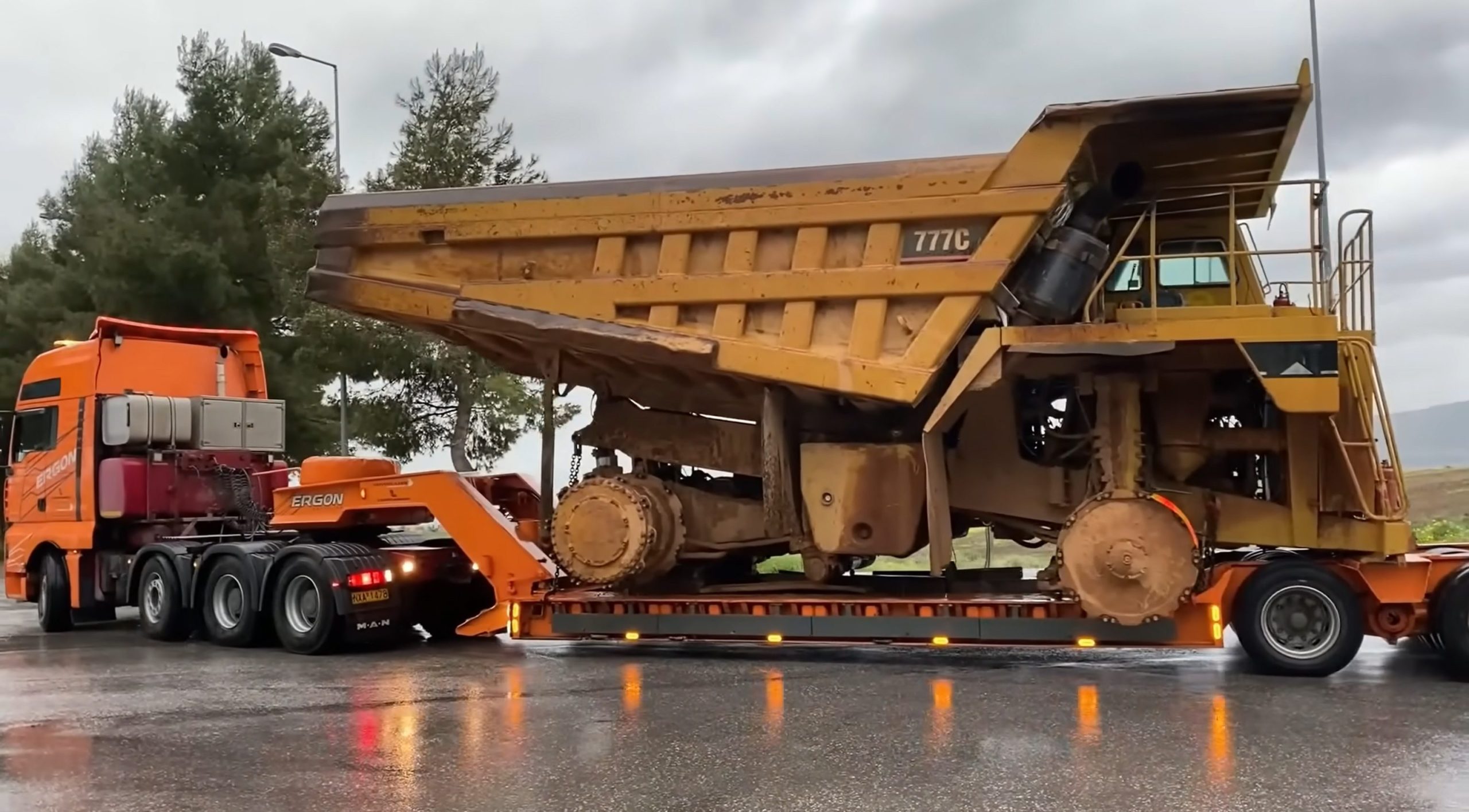 Transporting Caterpillar 777C dumper in wet road